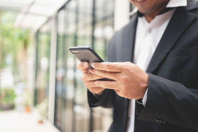 Midsection of businessman using mobile phone