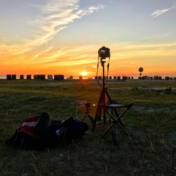 Lifeguard hut on field against sky during sunset