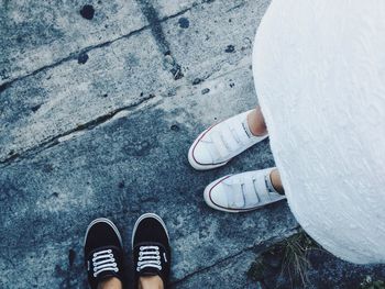 Low section of couple standing on footpath