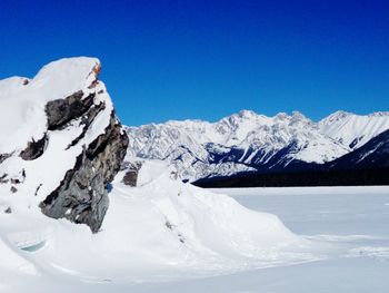 Scenic view of snowcapped mountains against clear blue sky