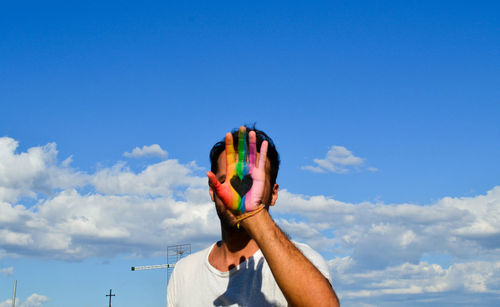 Low angle view of man hand against sky