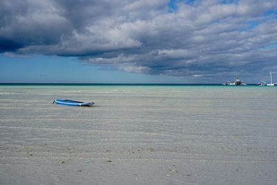 Boat moored on sea against sky