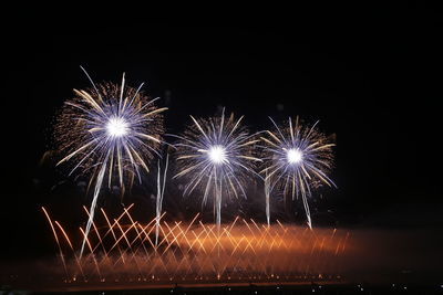 Low angle view of firework display at night