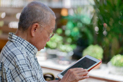 Side view of man using mobile phone outdoors