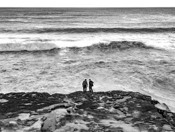 People standing on beach by sea