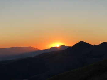 Scenic view of silhouette mountains against sky during sunset