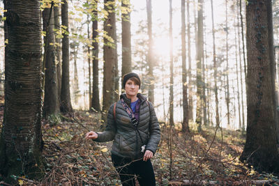 Portrait of young woman standing in forest