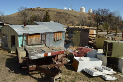 Junkyard and house against mountain