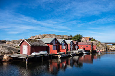 Houses by lake against blue sky