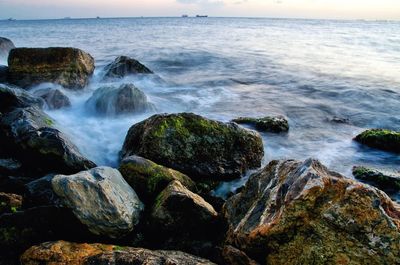 Rocks in sea against sky
