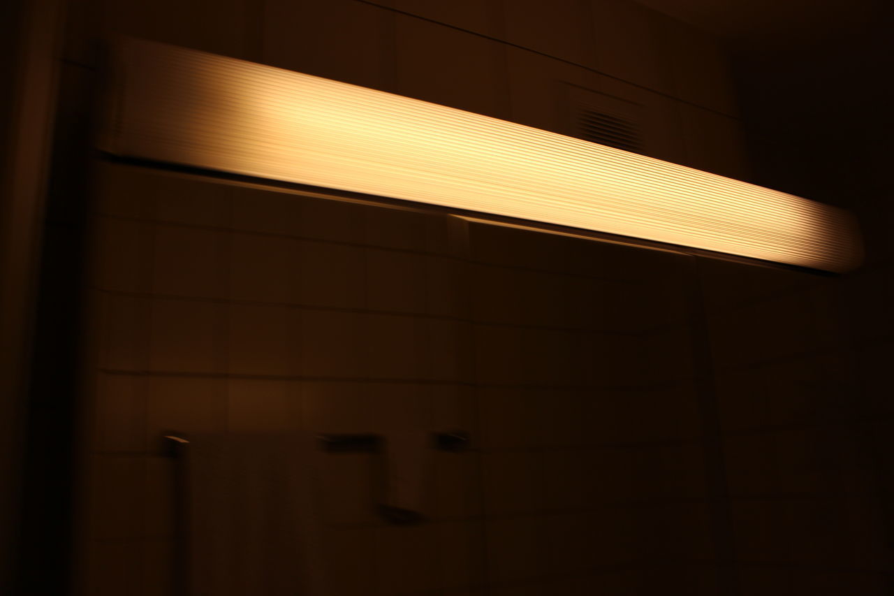 LOW ANGLE VIEW OF ILLUMINATED LIGHTS ON WALL