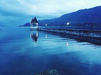 Scenic view of calm lake against cloudy sky