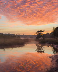 Scenic view of lake against orange sky