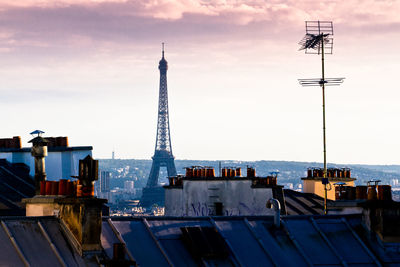 Communications tower in city against sky