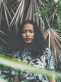Portrait of woman standing by plants