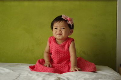 Portrait of cute girl sitting on bed