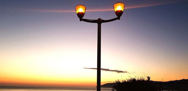 Street light against sky at sunset