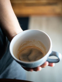 Midsection of person holding coffee cup