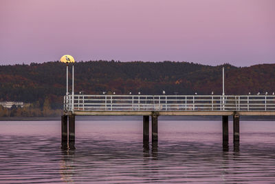 Jetty in lake against clear sky