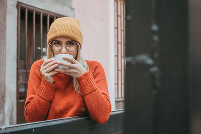 Portrait of young woman drinking coffee in cup
