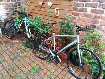 Bicycles parked against brick wall