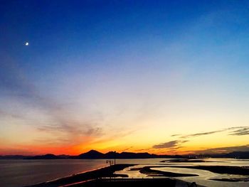 Scenic view of beach against clear sky during sunset