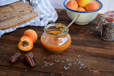 Close-up of preserve with apricot preserves and dates by herb and brown bread