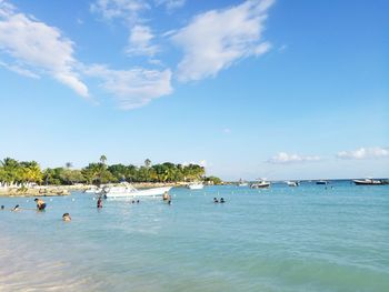 Scenic view of a group of people in the sea against sky