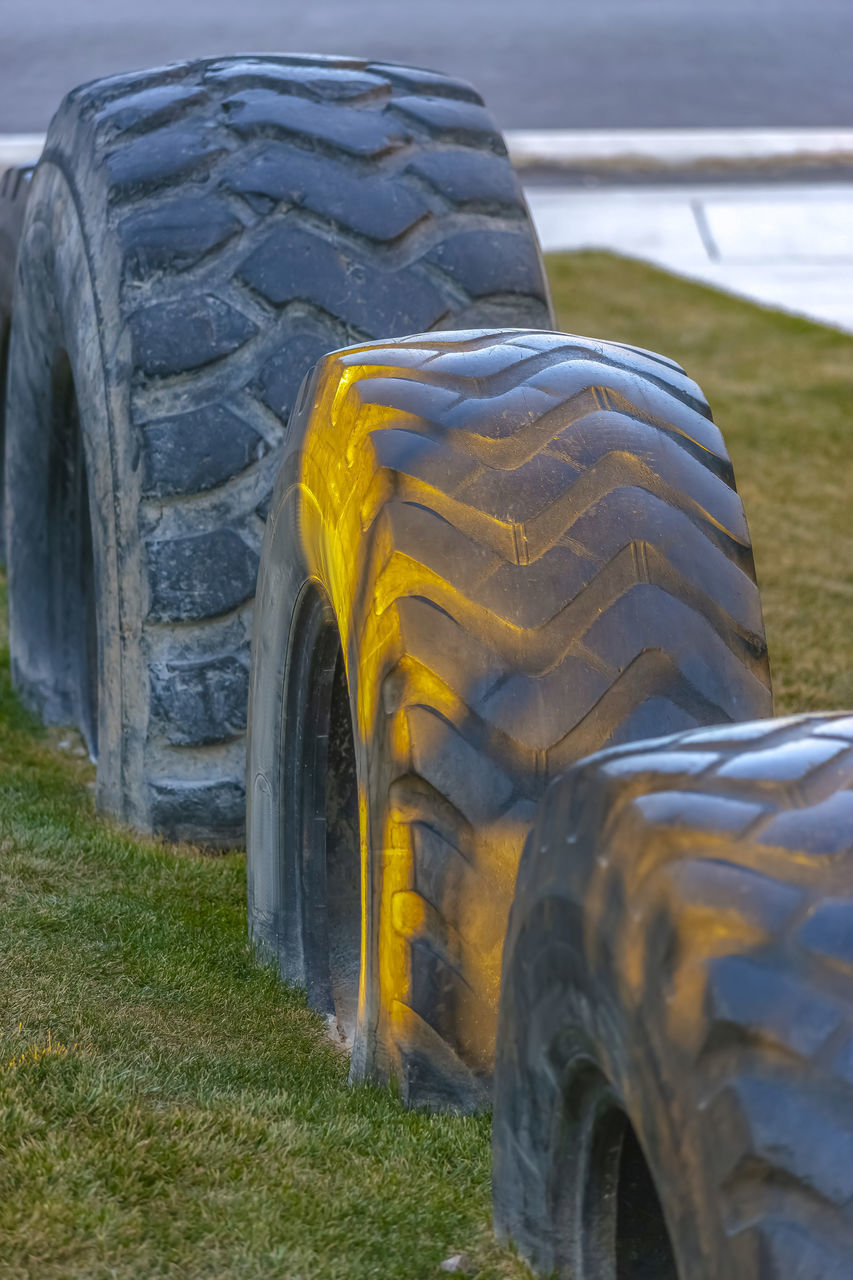 CLOSE-UP OF YELLOW TIRE ON FIELD