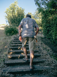 Rear view of man walking on field