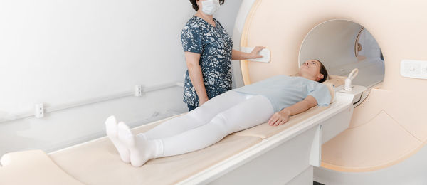 Rear view of woman sitting on bed at home