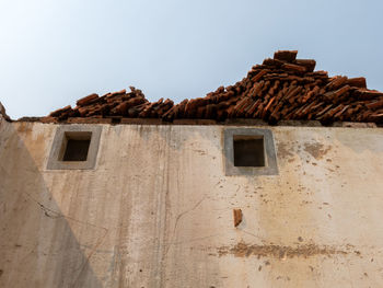 Low angle view of abandoned house against clear sky