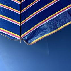 Low angle view of umbrella against blue sky