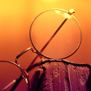 Close-up of sunglasses against orange background