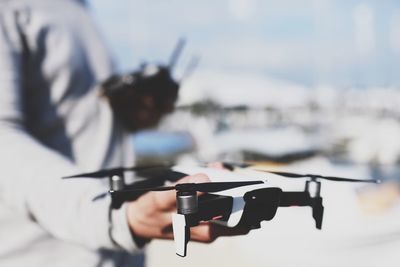 Midsection of man holding drone