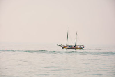 Sailboat sailing in sea against sky