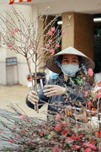 A woman selling peach blossom at a market in hanoi, vietnam, days before tet holiday 2021