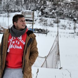 Man looking up while standing on snow covered field