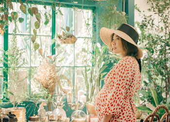 Portrait of woman with hat on plants