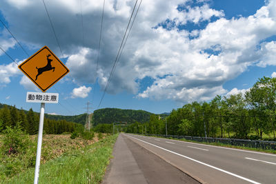 Road sign against sky