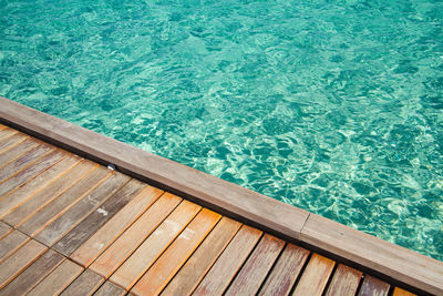Crystal clear water of the tropical sea and wood background