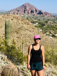 Smiling woman standing against landscape