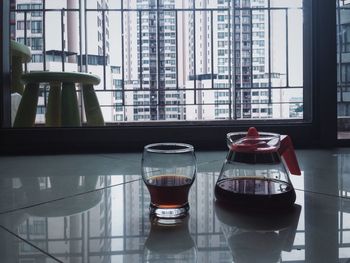 Coffee in jug and glass on floor at home