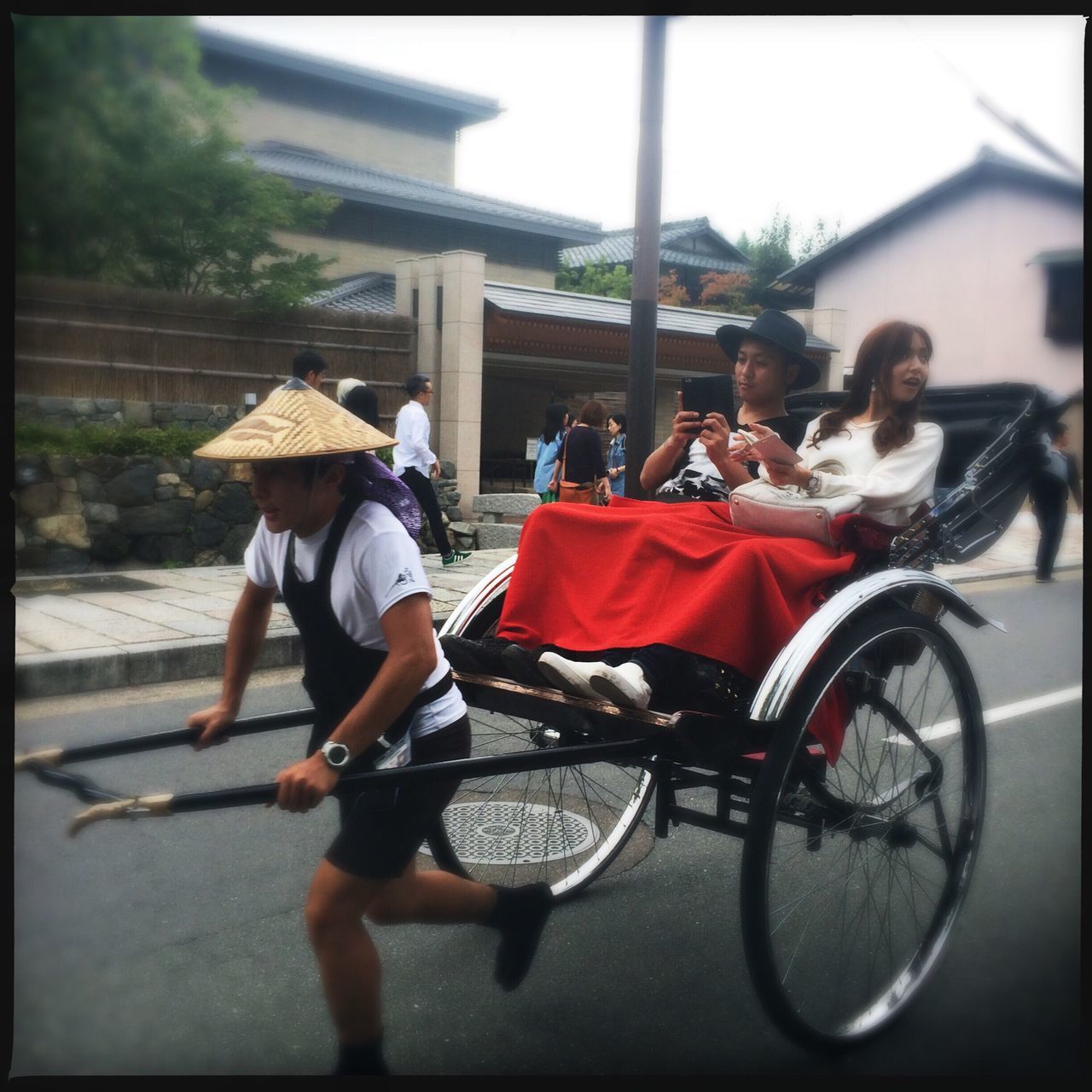 transfer print, mode of transport, transportation, land vehicle, men, building exterior, bicycle, street, auto post production filter, lifestyles, architecture, built structure, full length, leisure activity, city, person, casual clothing, domestic animals, day