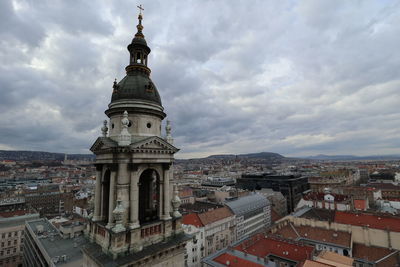 High angle view of buildings in city against cloudy sky