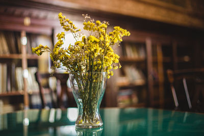 Close-up of yellow flower vase on table