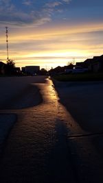 Road in city against sky during sunset