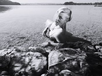 Portrait of woman wearing bikini lying at beach