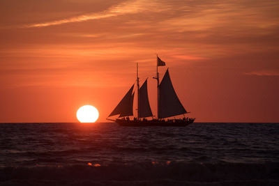 Sailboat sailing on sea against sky during sunset