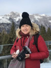 Portrait of smiling young woman standing on snow